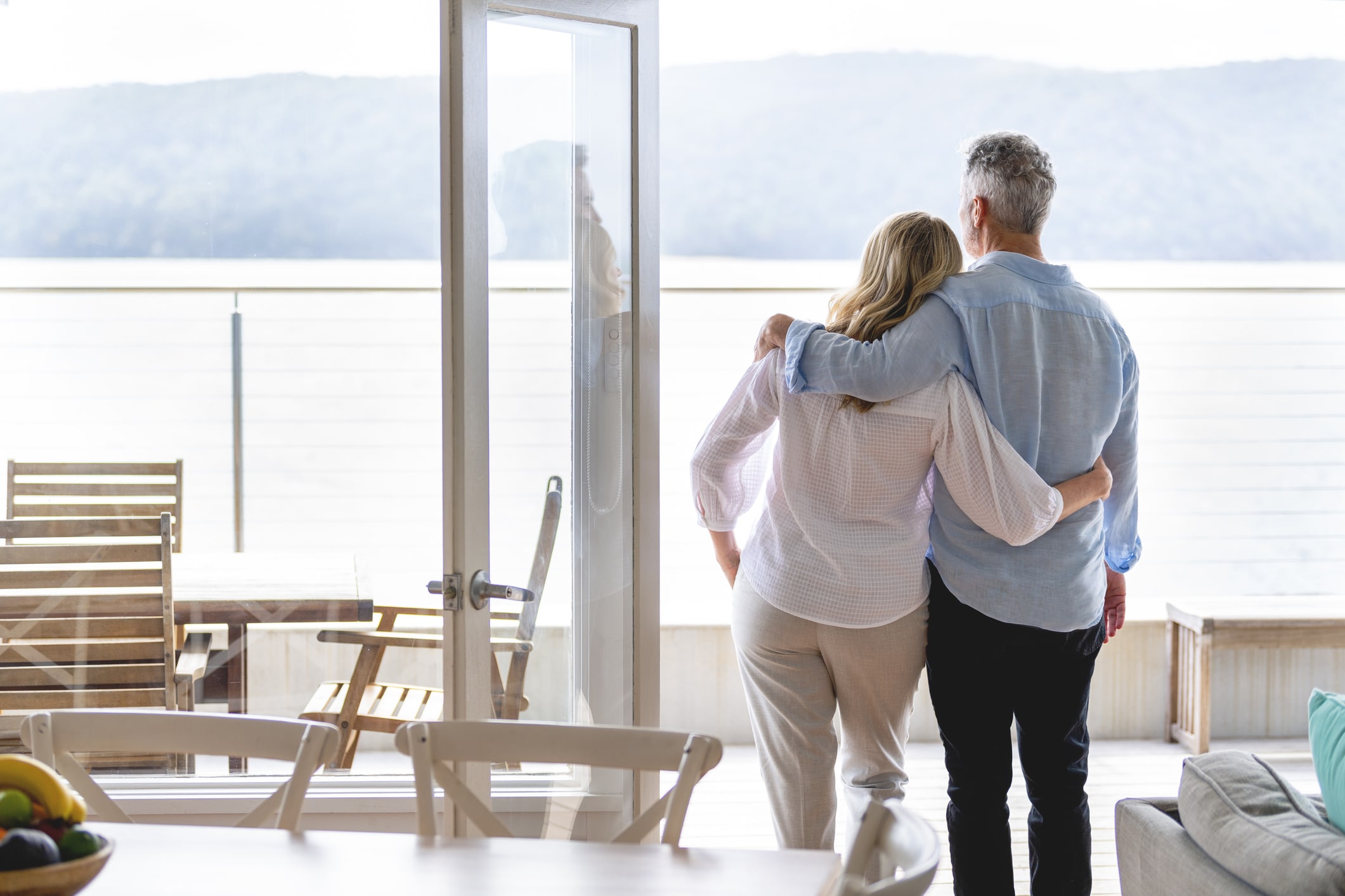 Couple standing together looking out a window at a scenic view