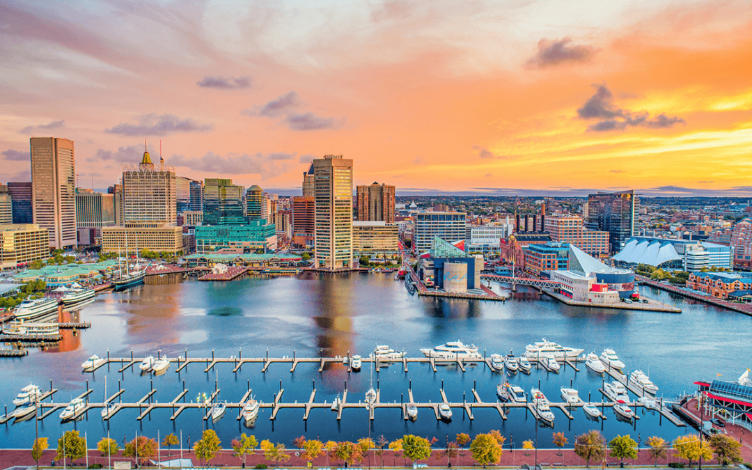 Baltimore Inner Harbor at sunset with yachts and city skyline.