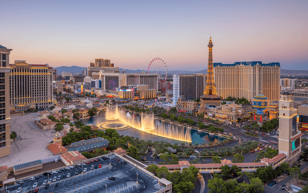 Las Vegas Strip with famous hotels and fountains at sunset.