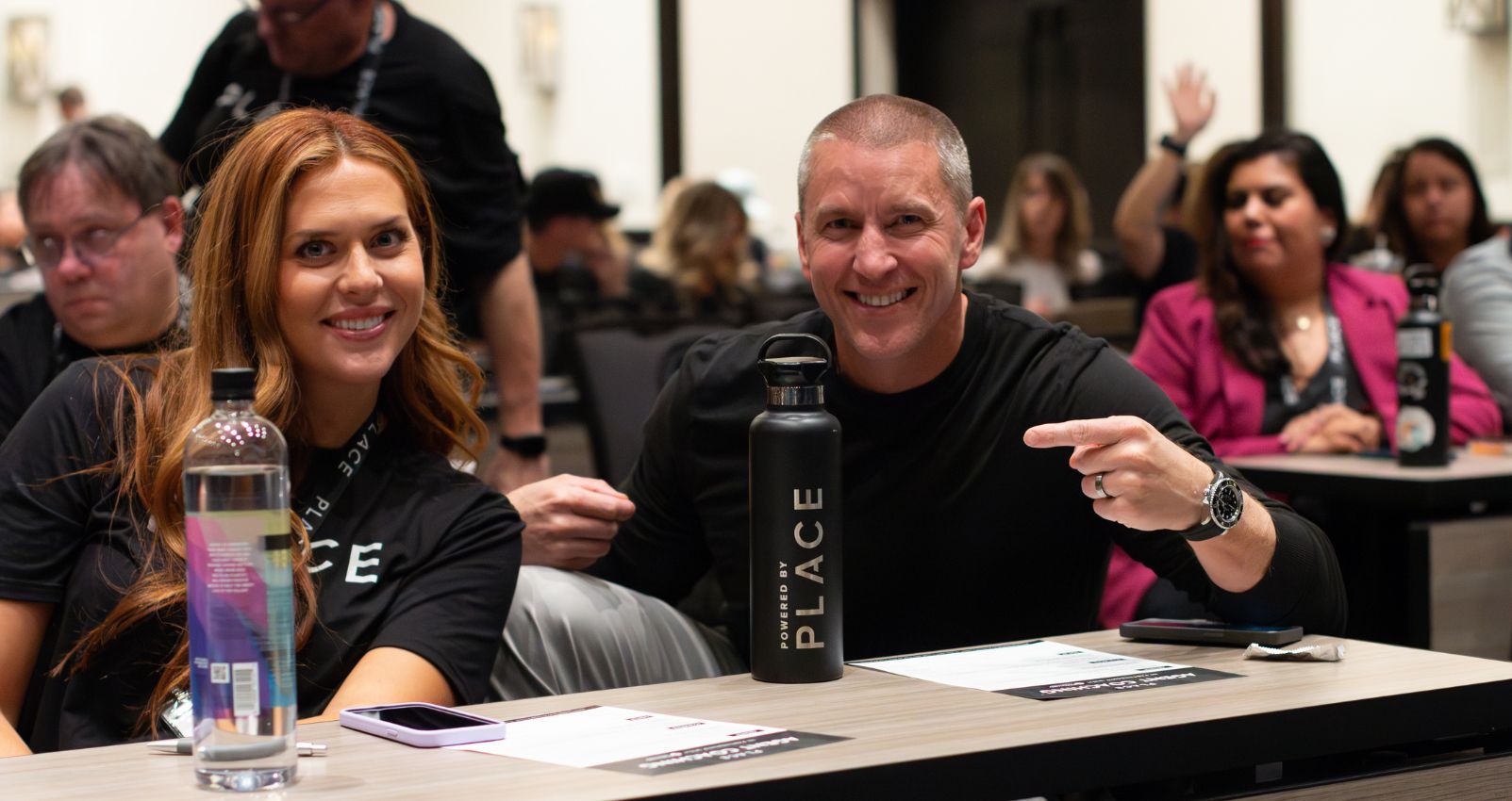Two professionals at a PLACE event smiling and engaging, representing the benefits of a flexible schedule in the workplace.